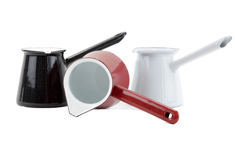 ři smaltované džezvy na kávu – černá, bílá a červená barva, postavené vedle sebe